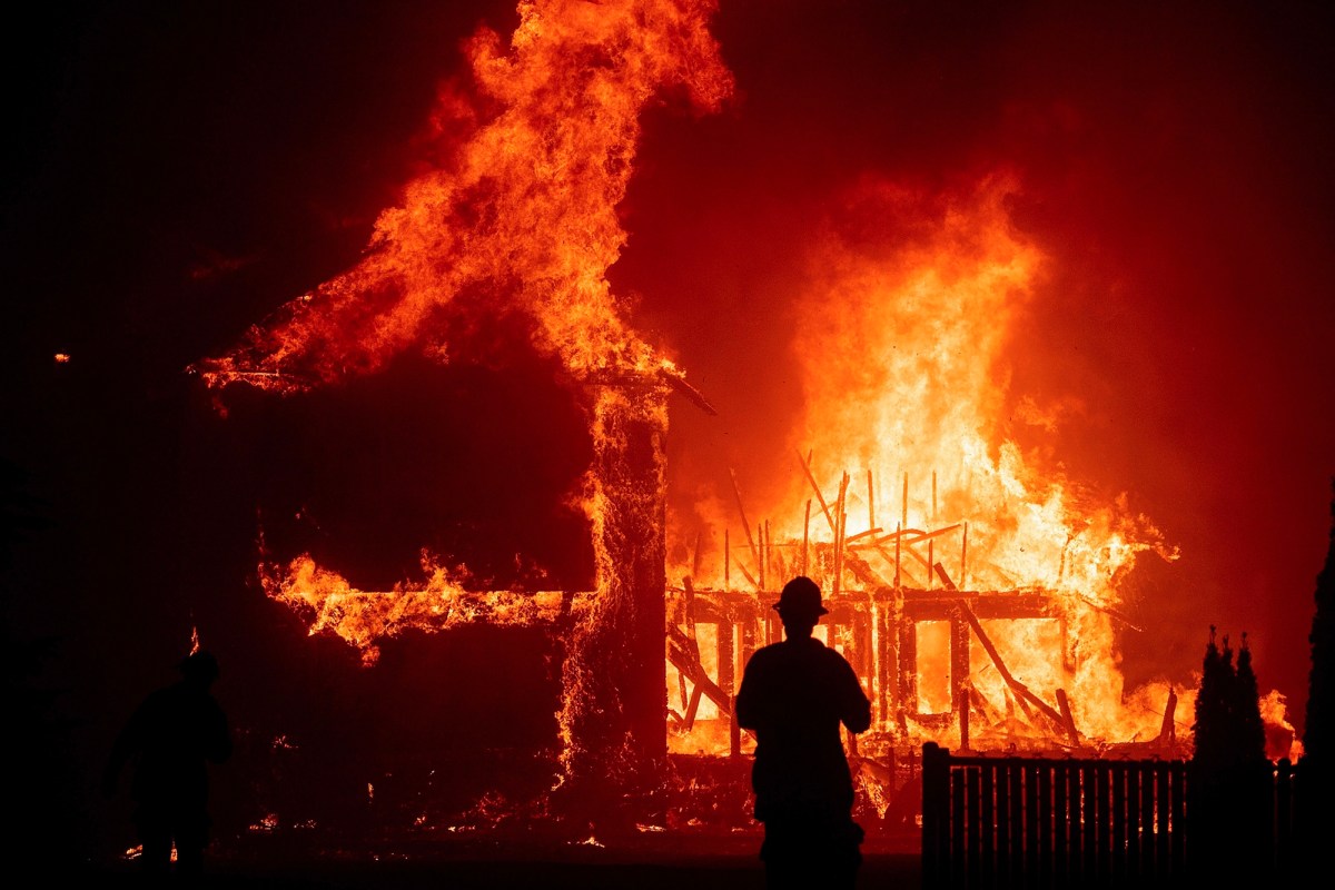 Home engulfed in wildfire flames, illustrating the devastating consequences that drive insurance non-renewals